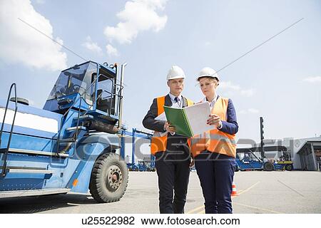 Engineers reading file in shipping yard View Large Photo Image Stock Image - Engineers reading file in shipping yard. Fotosearch