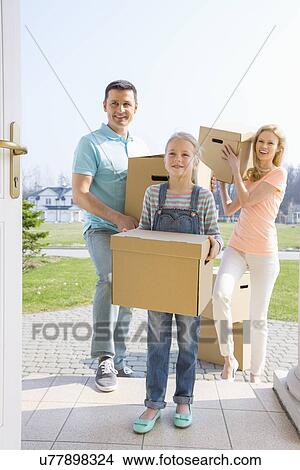 Family with cardboard boxes entering new house View Large Photo Image Picture - Family with cardboard boxes entering new house. Fotosearch