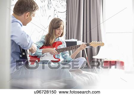 Father and daughter playing electric guitars at home View Large Photo Image Stock Image - Father and daughter playing electric guitars at home. Fotosearch