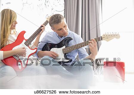 Father and daughter playing electric guitars at home View Large Photo Image Stock Photograph - Father and daughter playing electric guitars at home. Fotosearch