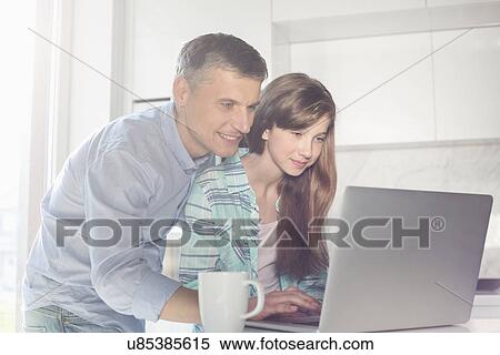 Father and daughter using laptop at home View Large Photo Image Stock Photography - Father and daughter using laptop at home. Fotosearch