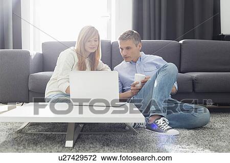 Father and daughter using laptop in living room View Large Photo Image Stock Image - Father and daughter using laptop in living room. Fotosearch
