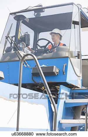 Female worker operating forklift truck in shipping yard View Large Photo Image Stock Image - Female worker operating forklift truck in shipping yard. Fotosearch