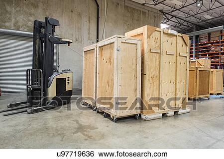 Stock Photograph - Forklift and wooden containers in manufacturing industry. Fotosearch