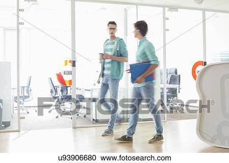 Full-length of businessmen walking at creative work space View Large Photo Image Stock Image - Full-length of businessmen walking at creative work space. Fotosearch