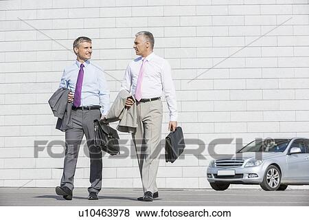 Full length of businessmen with briefcases walking on street View Large Photo Image Stock Photo - Full length of businessmen with briefcases walking on street. Fotosearch