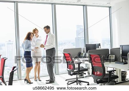 Full length of businesspeople discussing in office View Large Photo Image Stock Photography - Full length of businesspeople discussing in office. Fotosearch
