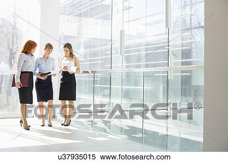 Full-length of businesswomen doing paperwork in office View Large Photo Image Stock Photography - Full-length of businesswomen doing paperwork in office. Fotosearch