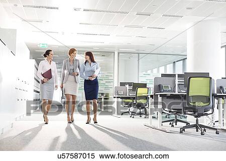 Full-length of businesswomen with file folders walking in office View Large Photo Image Stock Photography - Full-length of businesswomen with file folders walking in office. Fotosearch