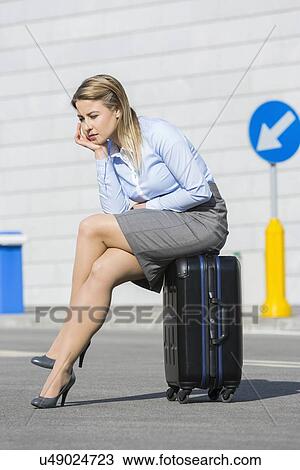 Full length of exhausted businesswoman sitting on luggage View Large Photo Image Stock Image - Full length of exhausted businesswoman sitting on luggage. Fotosearch