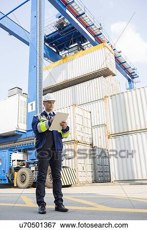 Full-length of male supervisor writing on clipboard in shipping yard View Large Photo Image Stock Photo - Full-length of male supervisor writing on clipboard in shipping yard. Fotosearch