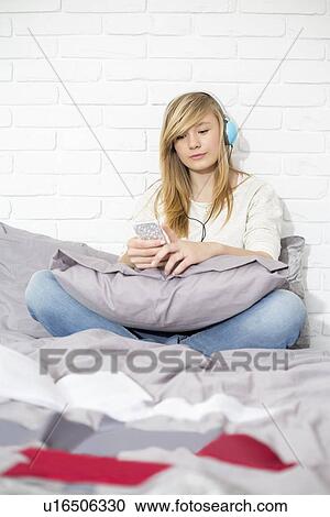 Full-length of teenage girl listening to music in bedroom View Large Photo Image Stock Image - Full-length of teenage girl listening to music in bedroom. Fotosearch