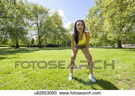 Full length of tired fit woman taking a break while exercising in park View Large Photo Image Stock Image - Full length of tired fit woman taking a break while exercising in park. Fotosearch
