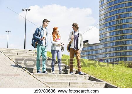 Full length of young college friends walking downstairs outdoors View Large Photo Image Stock Photograph - Full length of young college friends walking downstairs outdoors. Fotosearch