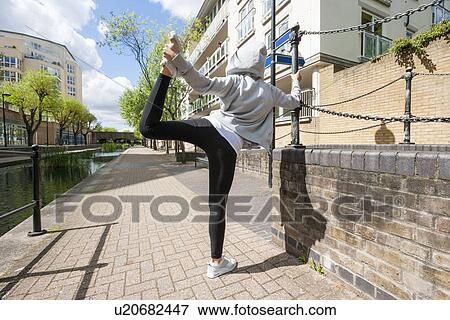 Full length rear view of fit woman performing stretching exercise on sidewalk View Large Photo Image Stock Photo - Full length rear view of fit woman performing stretching exercise on sidewalk. Fotosearch