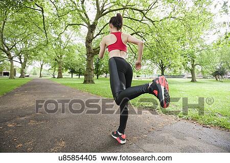 Stock Photography - Full length rear view of fit woman jogging in park. Fotosearch