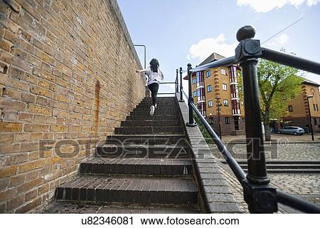 Full length rear view of young woman walking up stairs outdoors View Large Photo Image Stock Image - Full length rear view of young woman walking up stairs outdoors. Fotosearch