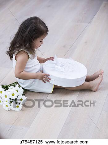 Full length side of little girl opening gift box on floor at home View Large Photo Image Stock Photography - Full length side of little girl opening gift box on floor at home. Fotosearch