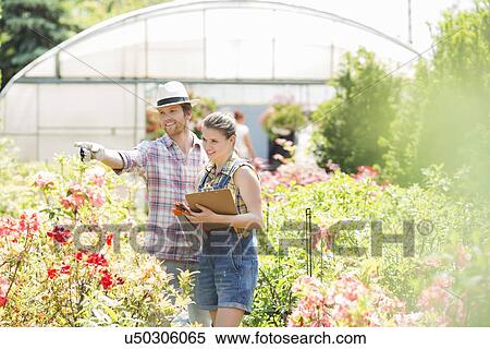 Stock Photography - Gardener discussing with supervisor outside greenhouse. Fotosearch