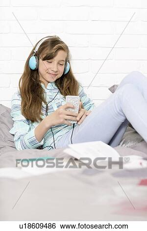 Girl listening to music at home View Large Photo Image Stock Photograph - Girl listening to music at home. Fotosearch