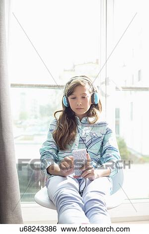 Girl listening to music at home View Large Photo Image Stock Photograph - Girl listening to music at home. Fotosearch