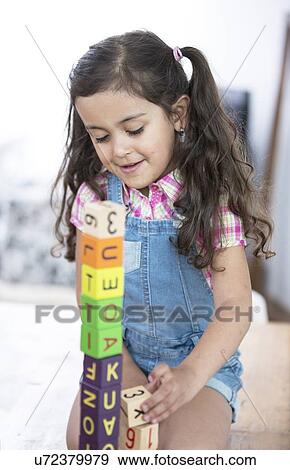 Stock Photo - Girl playing with blocks at home. Fotosearch