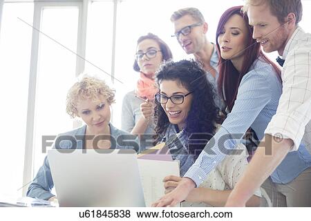 Group of creative businesspeople using laptop in office View Large Photo Image Stock Photo - Group of creative businesspeople using laptop in office. Fotosearch
