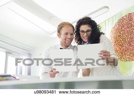 Stock Image - Happy business colleagues examining samples in creative office. Fotosearch