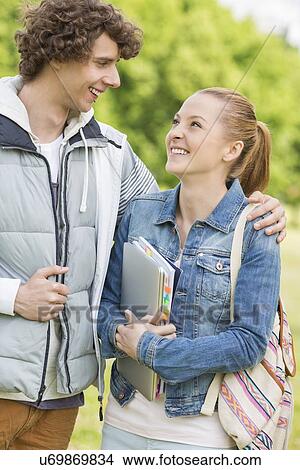 Happy college students looking at each other at campus View Large Photo Image Picture - Happy college students looking at each other at campus. Fotosearch