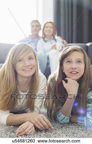 Happy family of four watching TV together at home View Large Photo Image Stock Image - Happy family of four watching TV together at home. Fotosearch