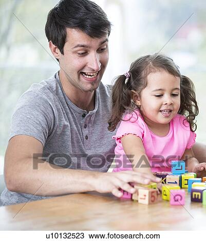 Happy father and daughter playing with building blocks at table in house View Large Photo Image Stock Image - Happy father and daughter playing with building blocks at table in house. Fotosearch