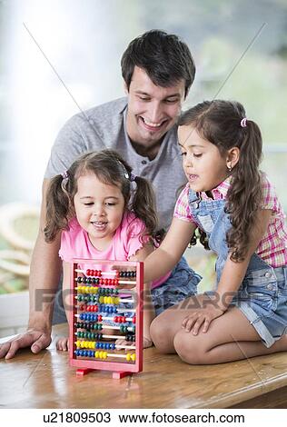 Happy father and daughters playing with abacus in house View Large Photo Image Stock Image - Happy father and daughters playing with abacus in house. Fotosearch