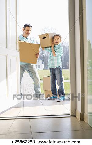 Stock Photo - Happy father and son with cardboard boxes entering into new house. Fotosearch