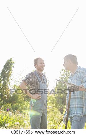 Happy gardeners conversing at plant nursery View Large Photo Image Stock Photography - Happy gardeners conversing at plant nursery. Fotosearch