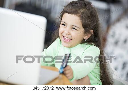 Happy girl using laptop and credit card to shop online at home View Large Photo Image Stock Image - Happy girl using laptop and credit card to shop online at home. Fotosearch