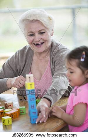 Happy grandmother and granddaughter playing with alphabet blocks in house View Large Photo Image Stock Photography - Happy grandmother and granddaughter playing with alphabet blocks in house. Fotosearch
