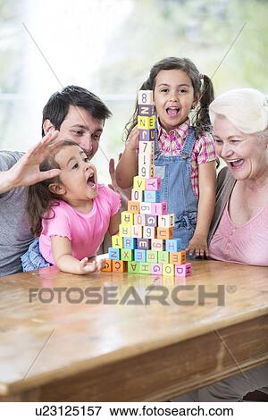 Happy multi generation family with arranged building blocks at table in house View Large Photo Image Stock Photo - Happy multi generation family with arranged building blocks at table in house. Fotosearch