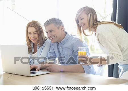 Happy parents with daughter using laptop at home View Large Photo Image Stock Image - Happy parents with daughter using laptop at home. Fotosearch