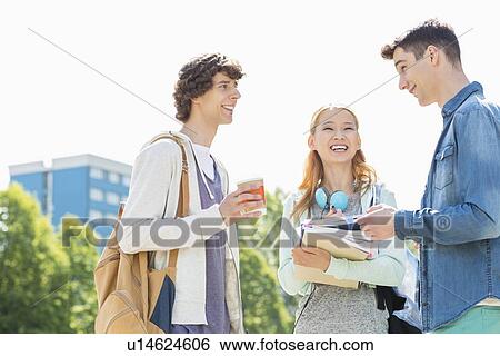 Stock Photograph - Happy university students conversing at campus. Fotosearch