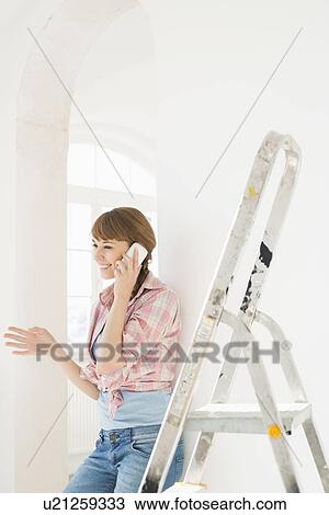 Happy woman using cell phone in new house View Large Photo Image Stock Image - Happy woman using cell phone in new house. Fotosearch