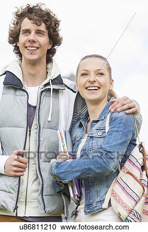 Happy young college students standing arm around at campus View Large Photo Image Stock Image - Happy young college students standing arm around at campus. Fotosearch