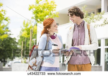 Stock Image - Happy young man and woman studying together at college campus. Fotosearch