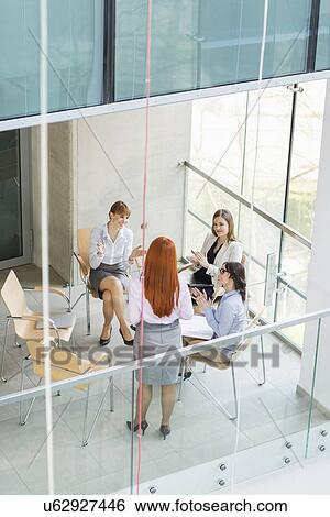 High angle view of businesswoman giving presentation to colleagues in office View Large Photo Image Stock Photograph - High angle view of businesswoman giving presentation to colleagues in office. Fotosearch