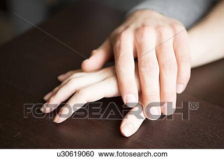 Loving couple's hands on table View Large Photo Image Stock Image - Loving couple's hands on table. Fotosearch