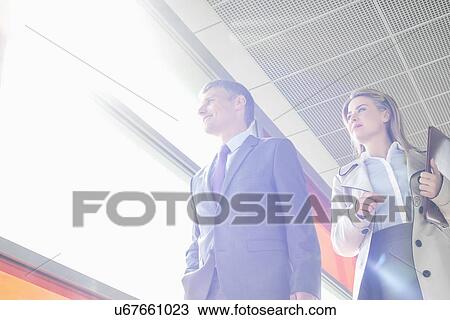 Low angle view of business people walking in railroad station View Large Photo Image Stock Image - Low angle view of business people walking in railroad station. Fotosearch
