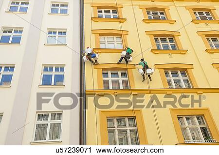Low angle view of window washers hanging outside building View Large Photo Image Stock Image - Low angle view of window washers hanging outside building. Fotosearch