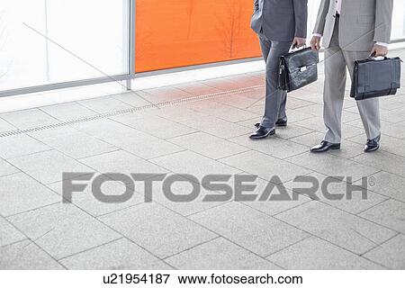 Low section of businessmen with briefcase walking in railroad station View Large Photo Image Stock Photo - Low section of businessmen with briefcase walking in railroad station. Fotosearch