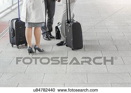 Low section of businesspeople with luggage standing on railroad platform View Large Photo Image Stock Image - Low section of businesspeople with luggage standing on railroad platform. Fotosearch