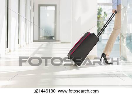 Low section of businesswoman with luggage leaving airport View Large Photo Image Stock Image - Low section of businesswoman with luggage leaving airport. Fotosearch