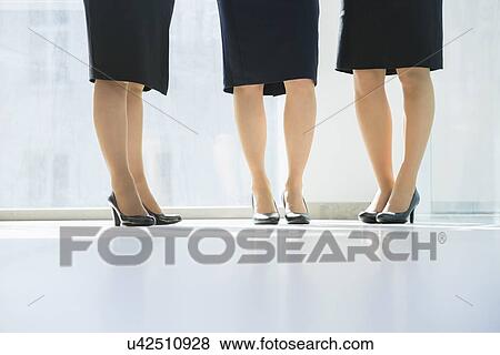 Low section of businesswomen standing in office View Large Photo Image Stock Photo - Low section of businesswomen standing in office. Fotosearch